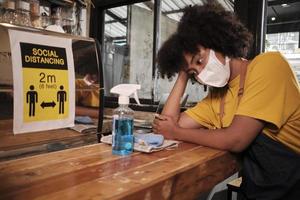 barista de café feminino americano africano com máscara facial protetora esperando clientes em uma cafeteria, pequenas empresas no novo serviço de estilo de vida normal, impacto econômico da quarentena pandêmica covid19. foto