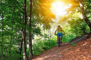 um jovem cavalgando uma mountain bike ao ar livre foto