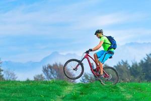 um jovem macho andando de bicicleta de montanha foto