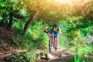 um jovem cavalgando uma mountain bike ao ar livre foto