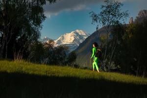 excursão de uma garota sozinha do final do dia com as cores do pôr do sol nas montanhas foto