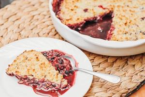 um pedaço de torta de frutas com topo crocante. usando bagas frescas de verão para assar. receita fácil. sapateiro feito de mirtilo e cranberry. foto