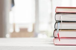 pilha de livros na mesa de madeira. conceito de aprendizagem de educação, biblioteca e leitura. procurando informações na enciclopédia. foto