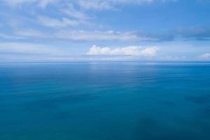 vista aérea de um fundo de textura de água de superfície de mar azul e reflexões de sol vista aérea de drone voador ondas textura de superfície de água no ensolarado oceano tropical na ilha de phuket, tailândia foto