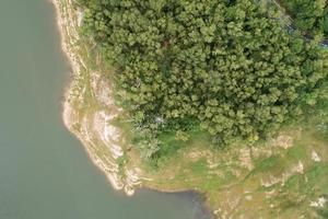 top down dos barragem lago montanhas com florestal verdes padrão lindos ensolarado dia verão tempo drone tiro aéreo vista nuvens irrigação natureza environment. foto