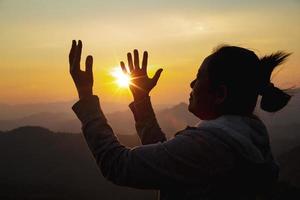 adoração de mulher no pôr do sol foto