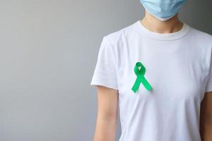 fita verde para fígado, vesícula biliar, ducto biliar, câncer cervical, renal e mês de conscientização do linfoma. conceito de saúde e dia mundial do câncer foto