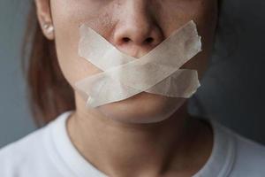 mulher com a boca selada em fita adesiva. liberdade de expressão, liberdade de imprensa, direitos humanos, ditadura de protesto, democracia, liberdade, igualdade e conceitos de fraternidade foto