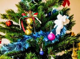 férias no conceito de cor vintage, bola de ouro pendurada no galho da árvore de natal com enfeites azuis, bola dourada e anjo branco foto