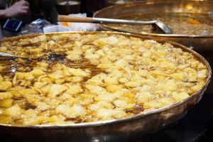 sopa de bucho de peixe cozido em panela grande no mercado de comida de rua tailandesa foto