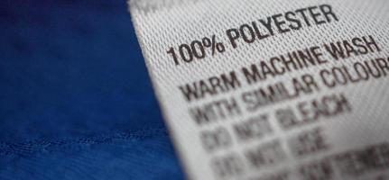 etiqueta de roupas de poliéster com etiqueta de instruções de cuidados com a lavanderia na camisa azul foto