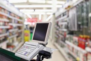 balcão de caixa de supermercado com terminal de pagamento foto