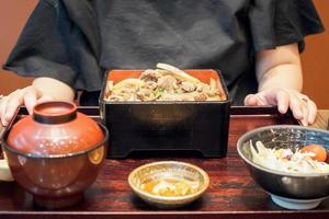 mulher asiática pronta para comer comida japonesa refeição de carne grelhada com arroz, gyu donburi em caixa bento foto