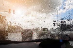 tráfego em dia chuvoso pesado com vista para a estrada dentro da janela do carro com gotas de chuva foto