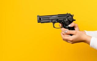 mãos e pistolas. mulher praticando tiro com uma carabina, prática de tiro simulada em um estúdio fotográfico. foto