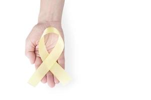 fita de cetim amarela na palma de uma mulher, isolada em um fundo branco. símbolo de conscientização do câncer, campanha de prevenção ao suicídio. copie o espaço. foto