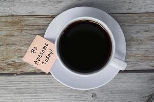 citação motivacional e inspiradora na nota da vara com xícara de café. foto