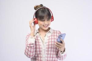 jovem mulher bonita usando fone de ouvido em fundo branco foto