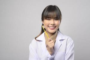 jovem dentista feminina sorrindo sobre estúdio de fundo branco foto