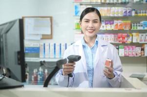 farmacêutico feminino escaneando código de barras em uma caixa de remédios em uma farmácia moderna. foto