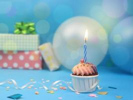 doce cupcake e vela de arco sobre fundo azul com espaço de cópia. feliz festa de aniversário foto