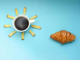 ideia criativa de café da manhã, céu azul da manhã do nascer do sol com refeição de nuvem, café preto quente, açúcar de manteiga de pão crocante e croissant. foto