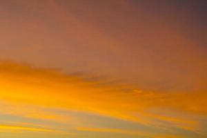 o céu é uma linha horizontal de amarelo-laranja e cores coloridas no lindo entardecer no meio da natureza que é tranquila, quente e romântica no campo e é extremamente bonita. foto