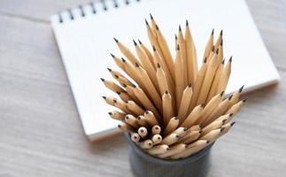 caderno de material escolar e lápis no espaço de trabalho. foto