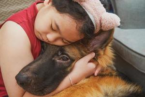 menina abraço cachorro foto