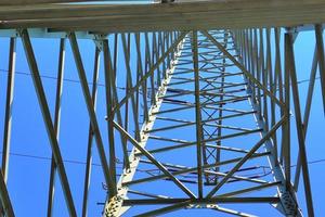 vista de perto em um grande poste de energia transportando eletricidade em uma área rural foto