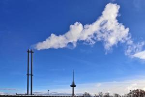 poluição da indústria de smostacks de fábrica em um céu azul profundo foto