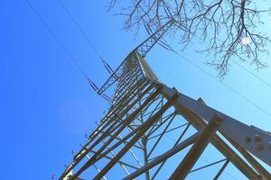 vista de perto em um grande poste de energia transportando eletricidade em uma área rural foto