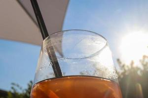 refrescantes coquetéis de verão laranja com gelo contra um fundo de céu azul. foto