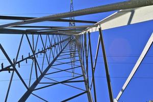 vista de perto em um grande poste de energia transportando eletricidade em uma área rural foto