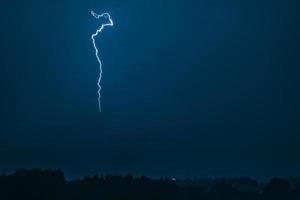 relâmpago no céu sobre a cidade. flashes brilhantes na noite escura. nuvens de trovoada e descargas de eletricidade na atmosfera. foto