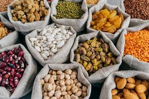 vários tipos de frutas secas e cereais no mercado de agricultores. feijão mungo, amêndoa, amora, grão de bico, passas. tiro de perto foto