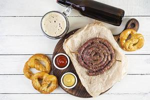 menu de comida para oktoberfest. salsicha com molho diferente, pretzel e copo de cerveja escura foto