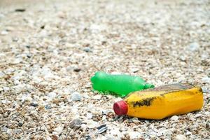 poluição da sujeira da praia, garrafas plásticas e outros lixos na praia. foto