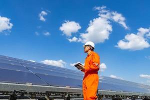 a fazenda solar, painel solar com engenheiros caminham para verificar o funcionamento do sistema, energia alternativa para conservar a energia do mundo, ideia de módulo fotovoltaico para produção de energia limpa foto