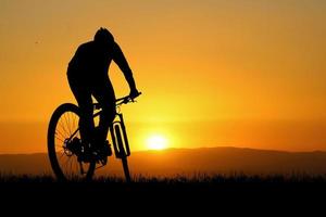 silhueta de ciclistas de montanha com belas vistas. conceito de exercício de bicicleta foto