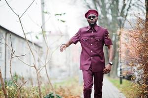 retrato de militar americano africano em uniforme vermelho, óculos escuros e boina. foto