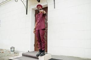 retrato de militar americano africano em uniforme vermelho e boina. foto