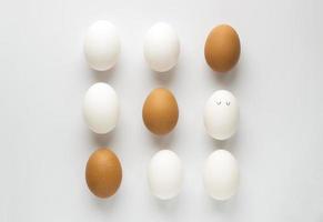 conjunto de ovo de galinha fresca em recipiente sobre fundo de papel branco. conceito para a páscoa com espaço de cópia. layout criativo feito de ovos brancos e marrons. foto vista superior