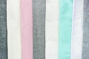 roupas coloridas de close-up dobradas em tira para segundo plano. vista superior de têxteis multicoloridos. conceito minimalista foto