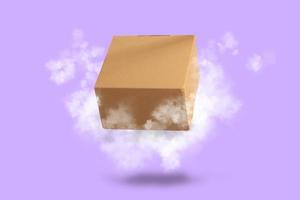 caixa de papelão marrom voando com nuvens no fundo roxo foto