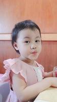 encantadora menina asiática de 2-3 anos de idade, lábios de beicinho de criança criança olhando para a câmera. foto