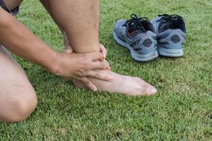 homem lesão no tornozelo depois de correr no campo de corrida foto