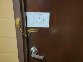 por favor, tranque a nota da porta na porta do banheiro com corrente foto