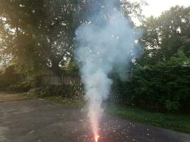 fogos de artifício coloridos acesos na calçada de asfalto com fumaça foto