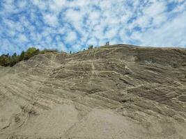 colina de rocha cinzenta ou montanha com céu azul e nuvens foto